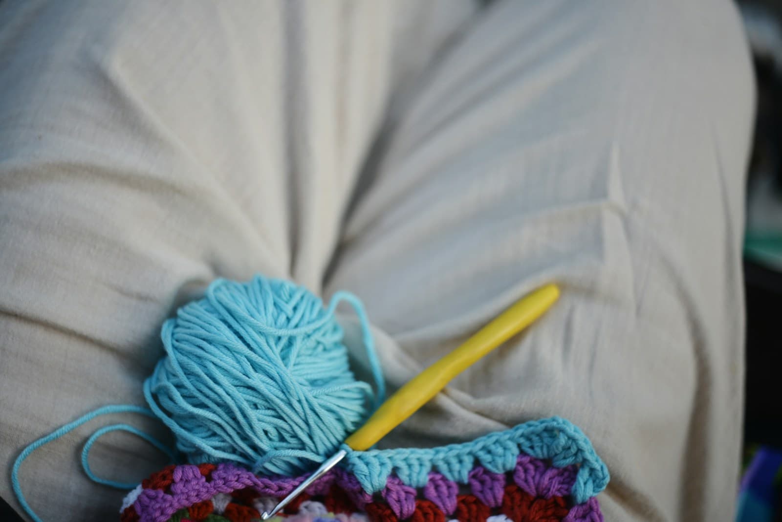 Hands crocheting with blue yarn, stitches in progress