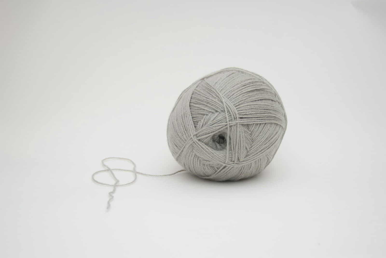 A single ball of yarn on a plain background, ready to be wound again