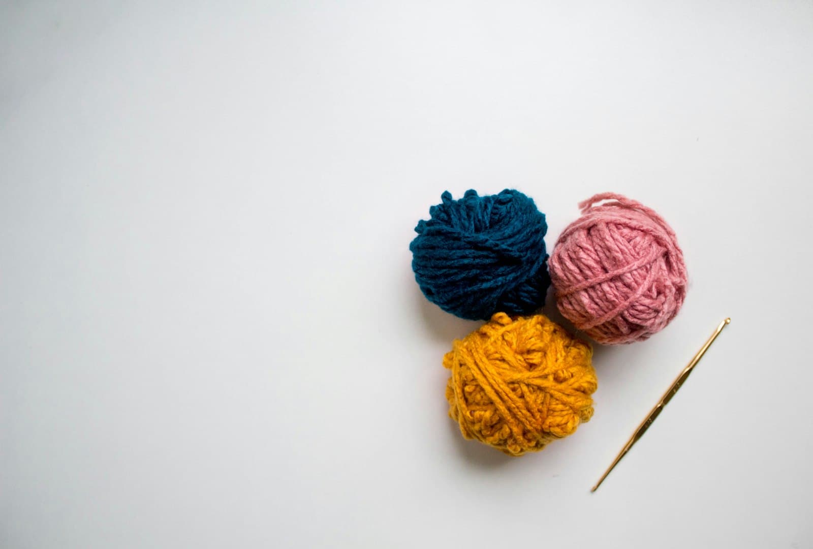 Blue and red balls of yarn on a white surface