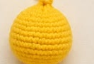 Finished round yellow crocheted Pikachu head and body piece, closed at the top after stuffing