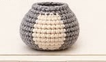 Finished grey and cream crocheted raccoon body, worked bottom-up with a cream band around the middle for the belly